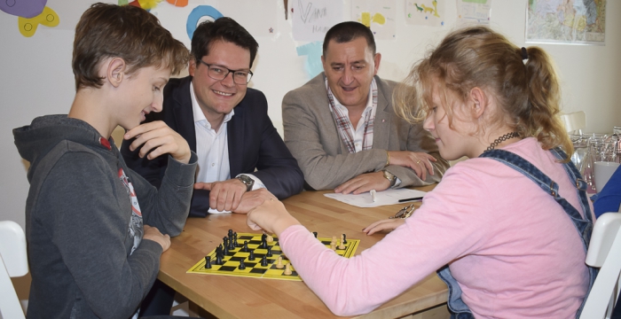 Stadtrat Czernohorszky und Bezirksvorsteher Derfler beobachten zwei Kinder beim Schachspielen © Jugend am Werk